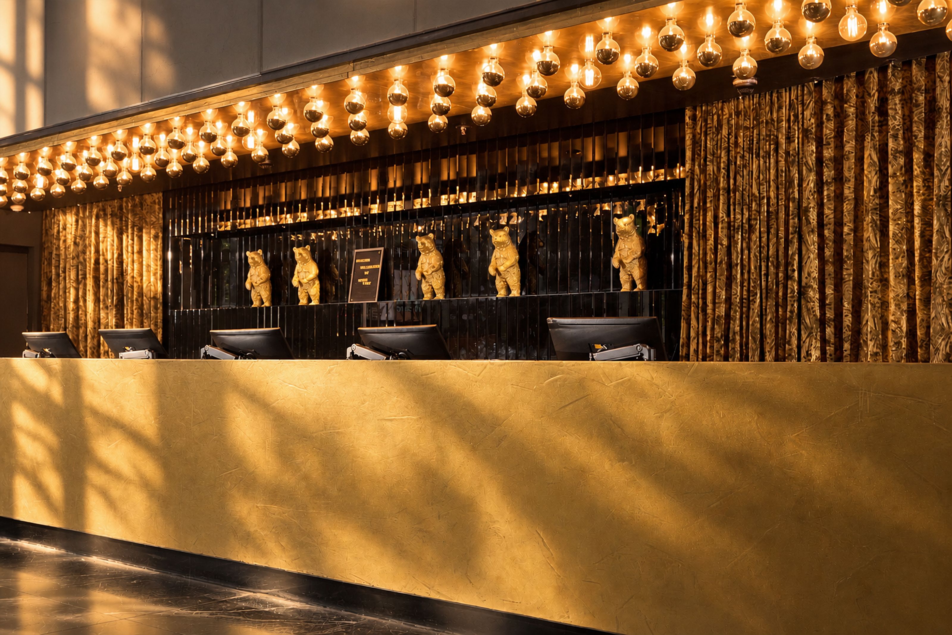 Rezeption mit warmem, goldenem Licht und dekorativen Bärenskulpturen, die eine einladende und elegante Atmosphäre schaffen.
