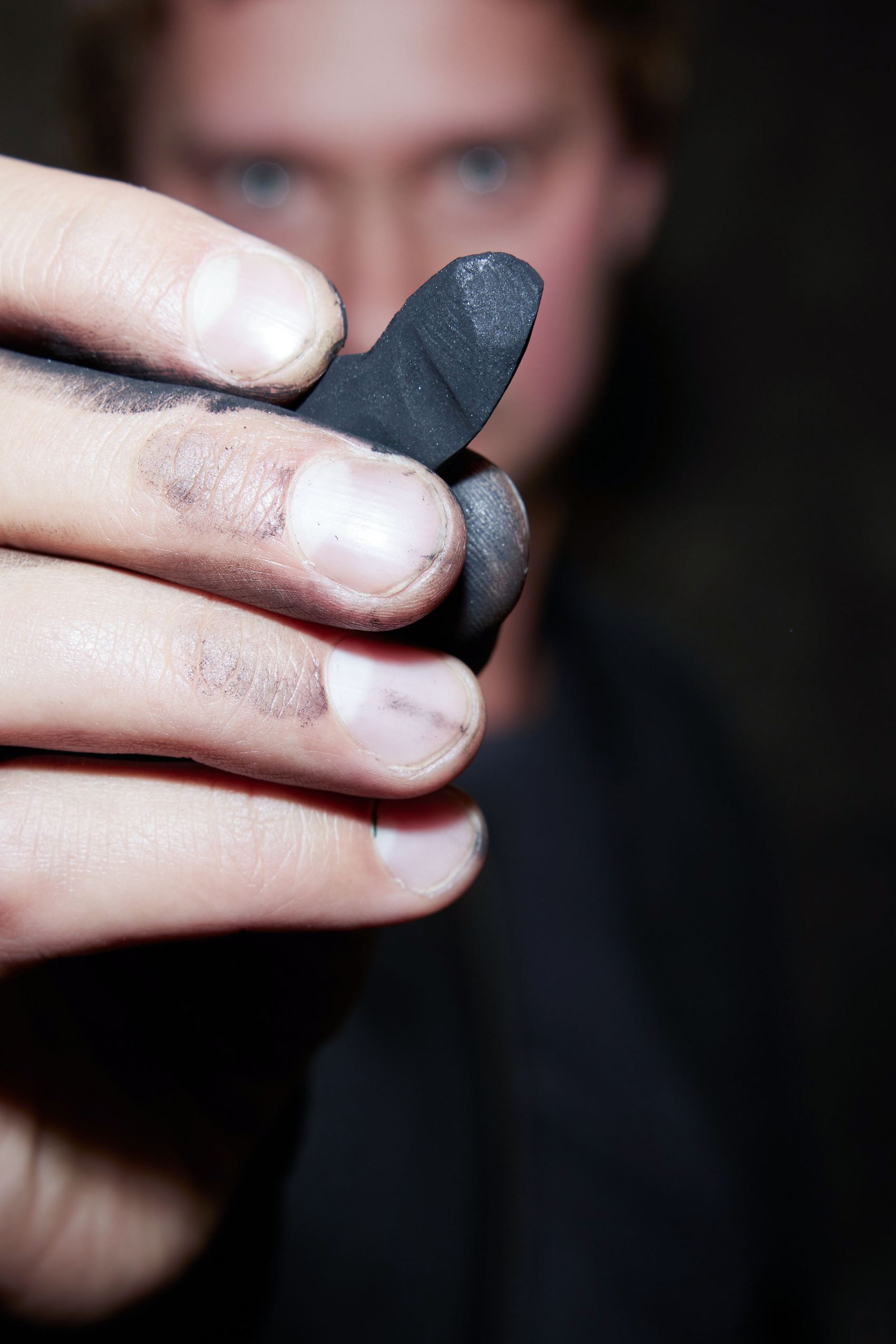 designhotel Gdansk The Cloud One artist Vasyl Savchenko holds a piece of natural charcoal up to the camera.