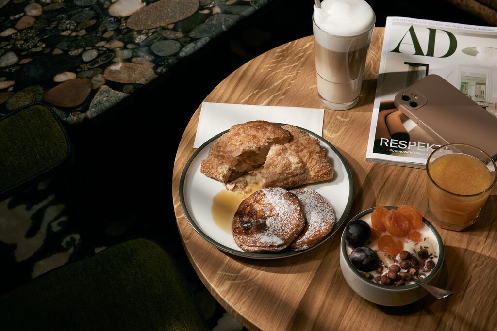 Hotel Danzig The Cloud One Frühstück auf einem Tisch mit Kaffee und Saft sowie ein Handy und eine Zeitschrift