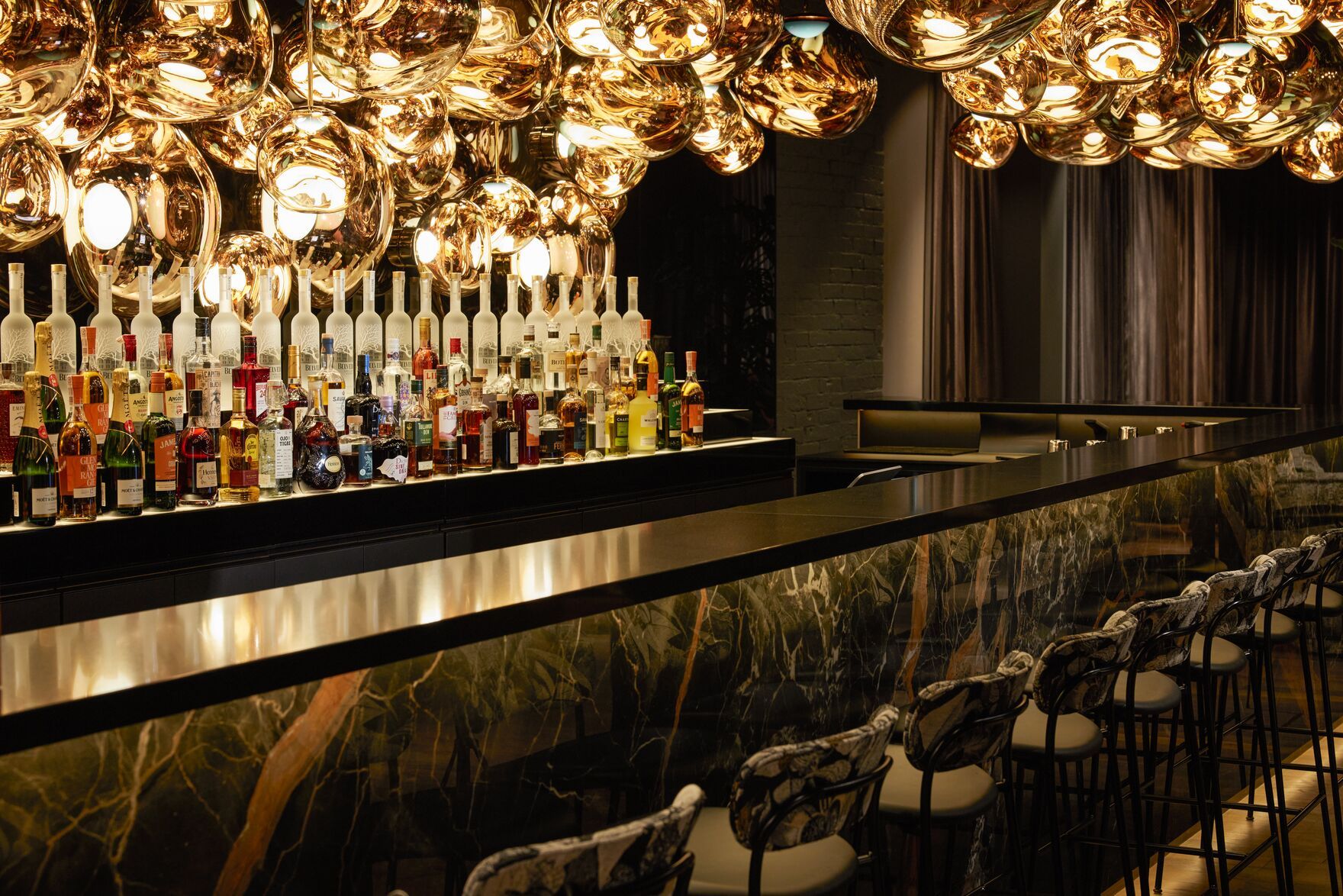 Designhotel Danzig The Cloud One große Bar mit Barhockern sowie Spirituosen und viele Lampen