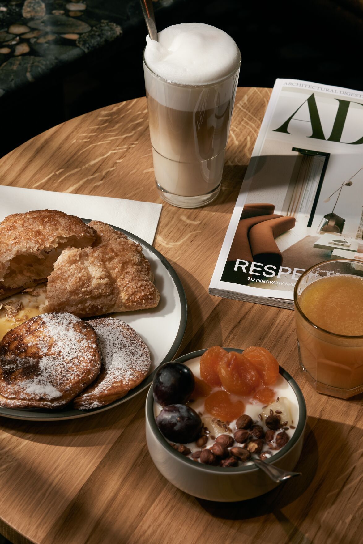 Designhotel Danzig The Cloud One Frühstückstisch mit Müsli, Backwaren, Kaffee, Saft und einer Zeitschrift