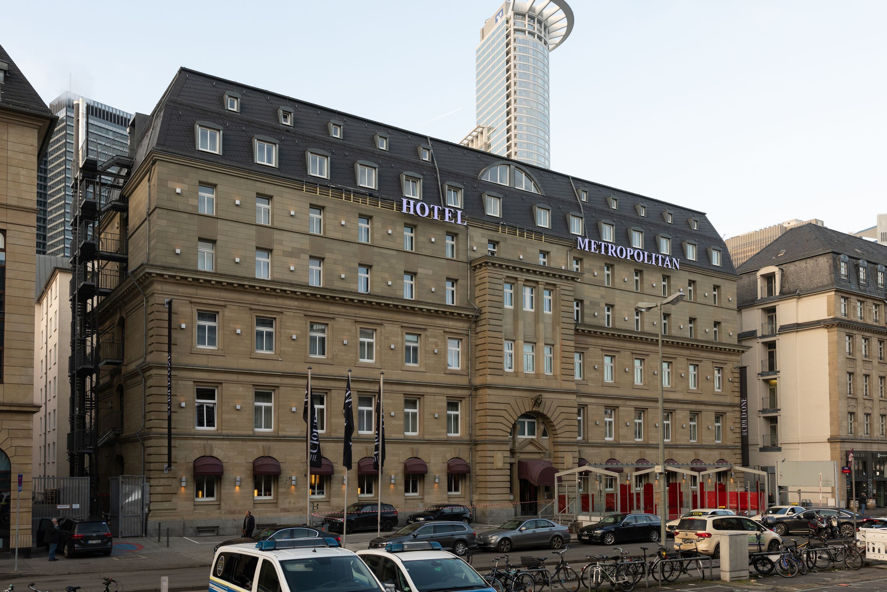 Hotel Frankfurt-Metropolitan The Cloud One Außenansicht des Hotels mit historischem Gebäude, zahlreichen Fenstern und rotem Eingangsbereich, zentral in einer Stadtkulisse gelegen.