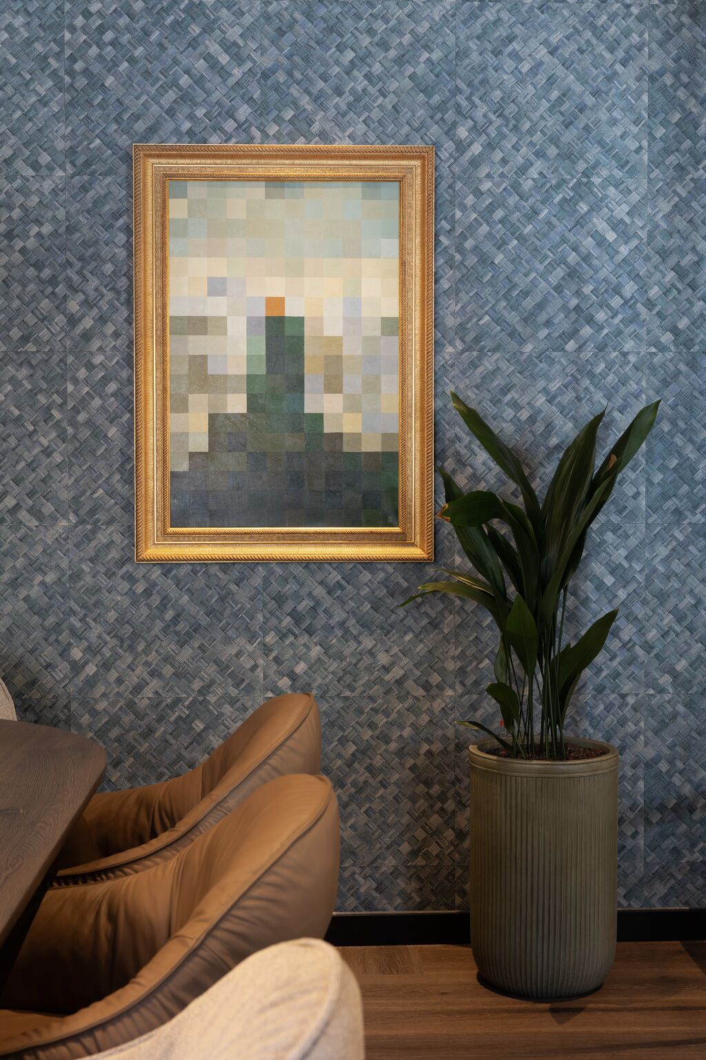 Hotel Frankfurt-Metropolitan The Cloud One Stühle vor stilvoller blauer Wandgestaltung, Pflanzen in grauem Topf und einem gerahmten Kunstwerk.