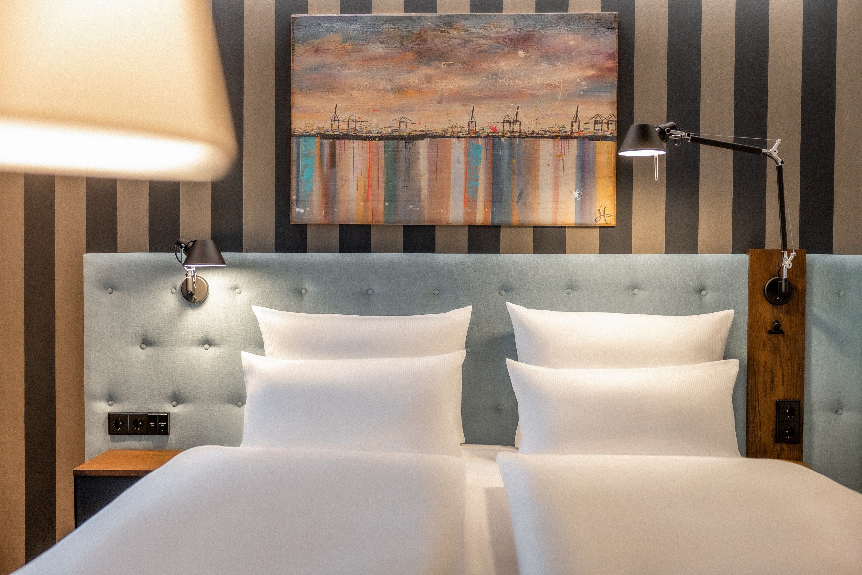 Hotel Hamburg Kontorhaus The Cloud One Doppelbett mit weißen Bettbezügen und Gemälde an gestreifter Wand