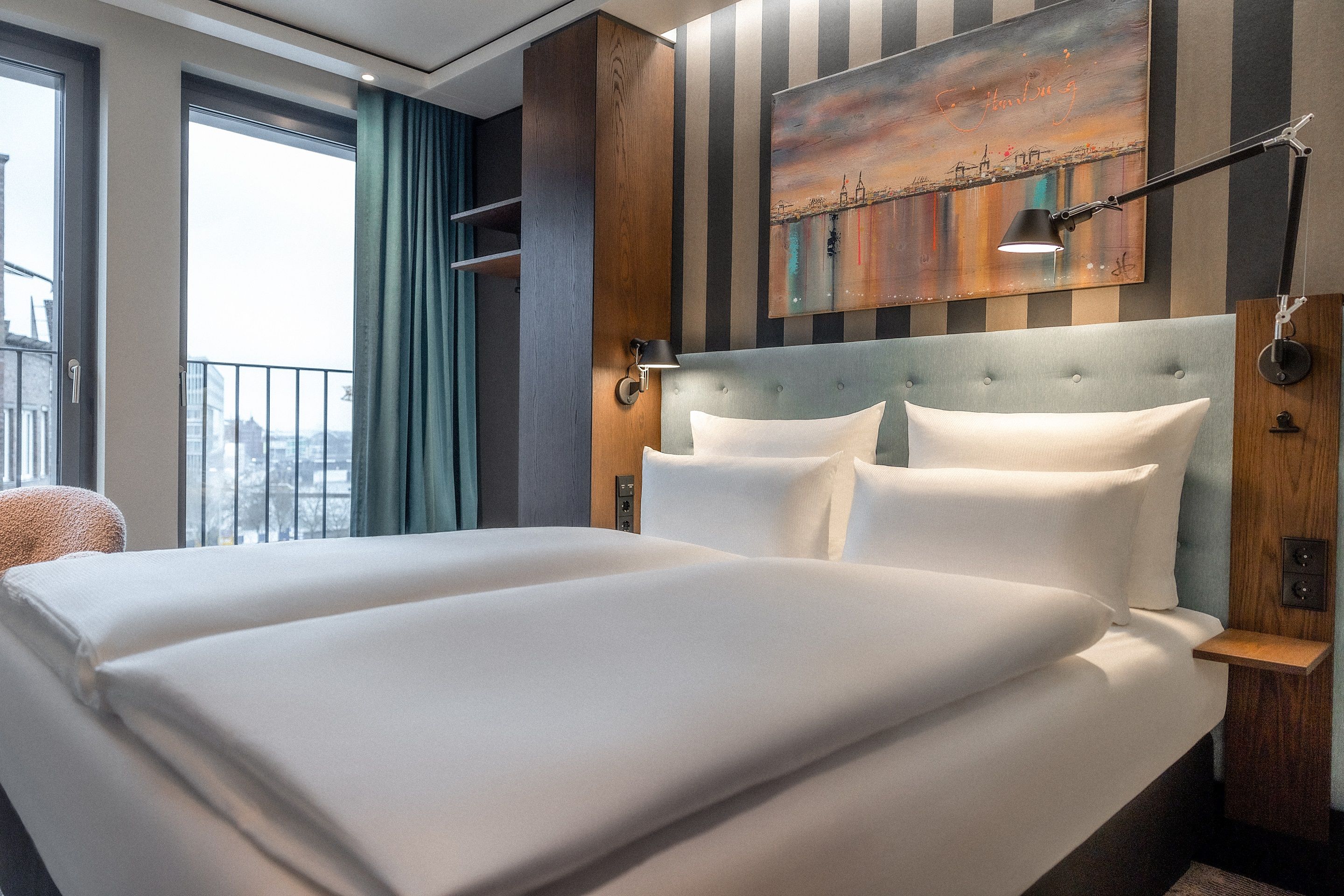 Hotel Hamburg Kontorhaus The Cloud One großes Doppelbett sowie offener Schrank und bodentiefe Fenster mit Ausblick
