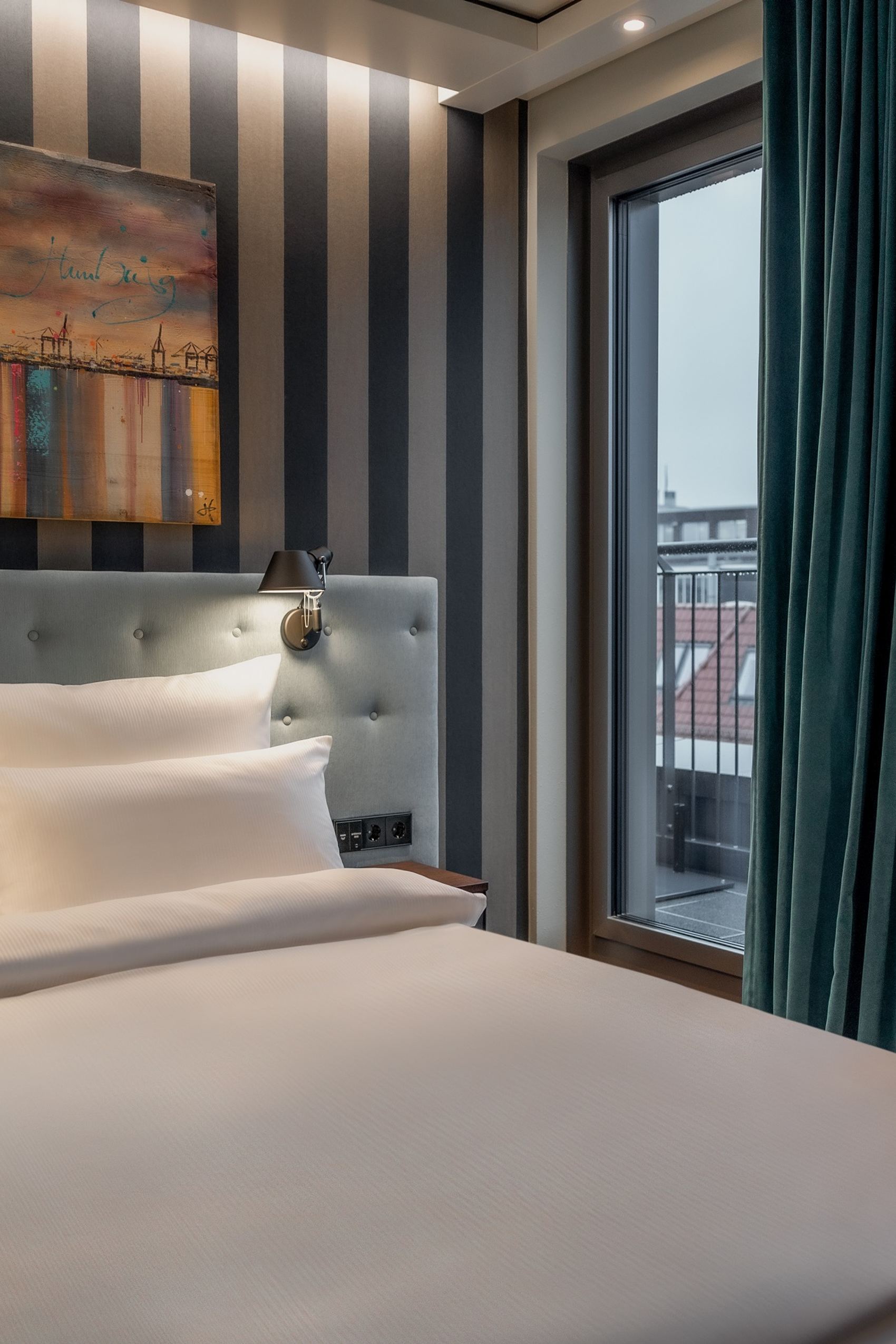 Hotel Hamburg Kontorhaus The Cloud One Zimmer mit großem Doppelbett, Gemälde über dem Bett sowie Balkonzugang