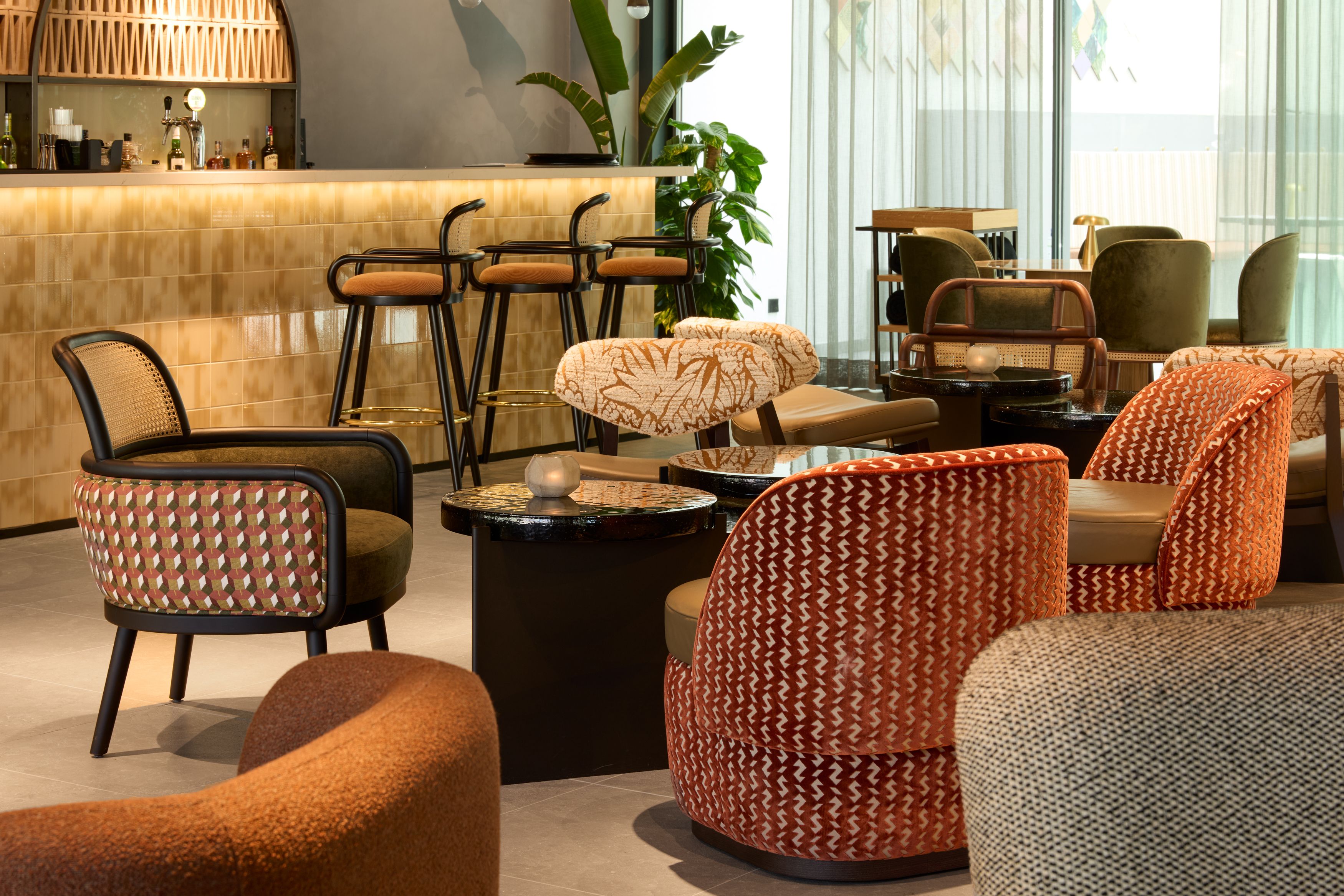 Hotel Lissabon The Cloud One Lounge und Bar mit modernem Design, warmen Farben und bequemen Sesseln sowie bodentiefen Fenstern im Hintergrund für viel Tageslicht.