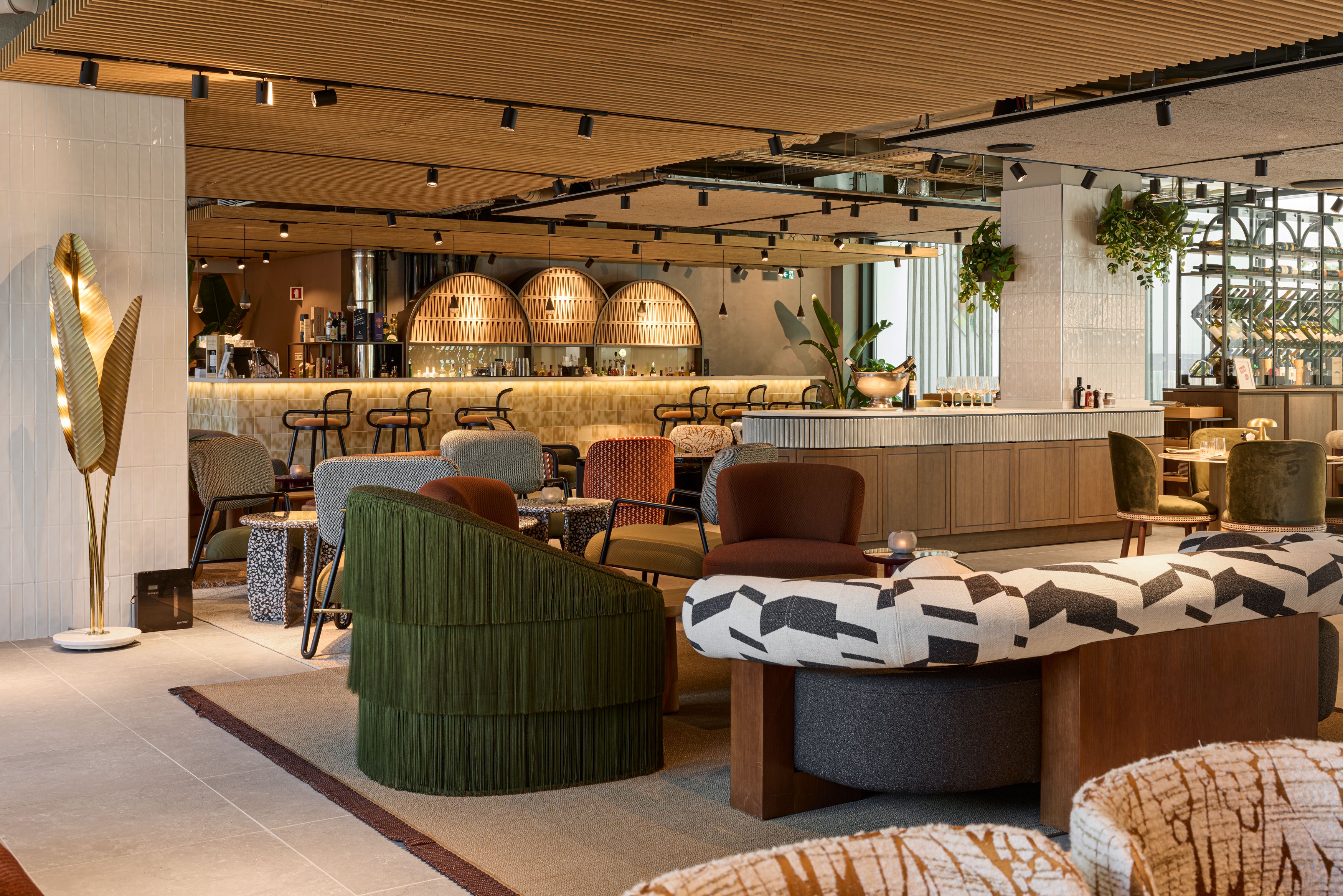 Hotel Lissabon The Cloud One Lounge und Barbereich mit Sitzgelegenheiten, warmem Holzdekor und atmosphärischer Beleuchtung.