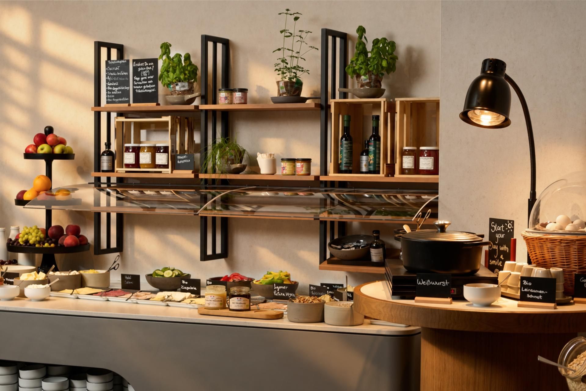 Buffet mit frischen Früchten, Aufstrichen, Honig und Kräutern, ausgestattet mit einer Wärmelampe und Holzregalen für ein gemütliches Frühstückserlebnis.