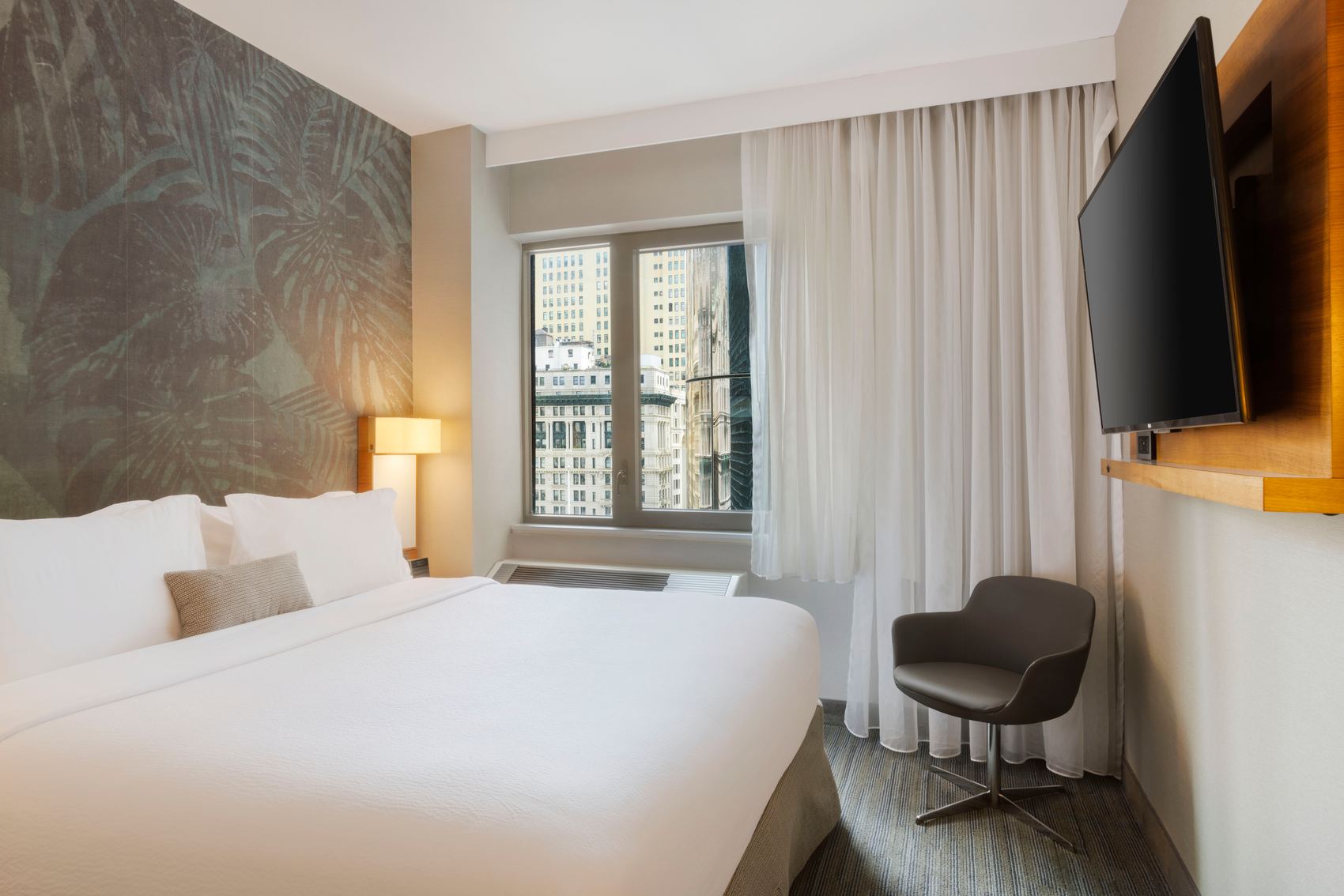 Designhotel New York Downtown The Cloud One helles Zimmer mit Doppelbett, Sessel und TV