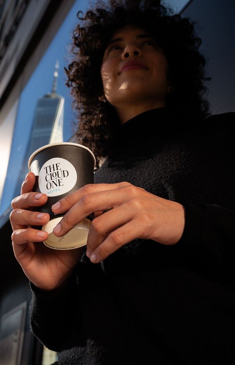 Designhotel New York Downtown The Cloud One Frau mit Deli-Kaffeebecher in den Händen