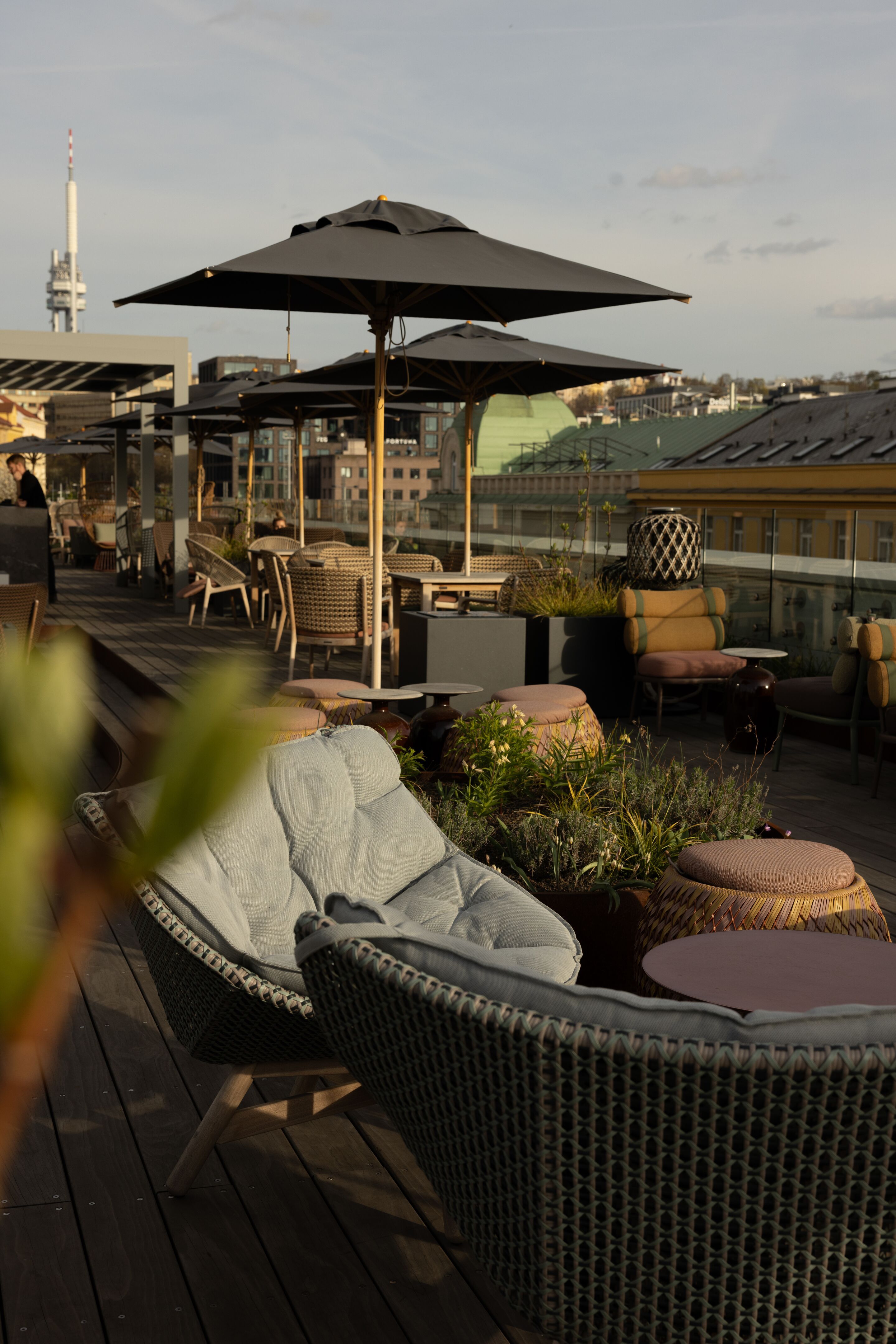 Designhotel Prag The Cloud One Dachterrasse mit mehreren Tischen und Stühlen sowie Sonnenschirme
