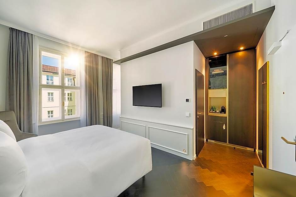 Helles, modernes Hotelzimmer mit großem Fenster, Tageslicht, bequemen Doppelbett, Wand-TV und elegante Holzböden. Ruhige, freundliche Atmosphäre für Erholung und Komfort.