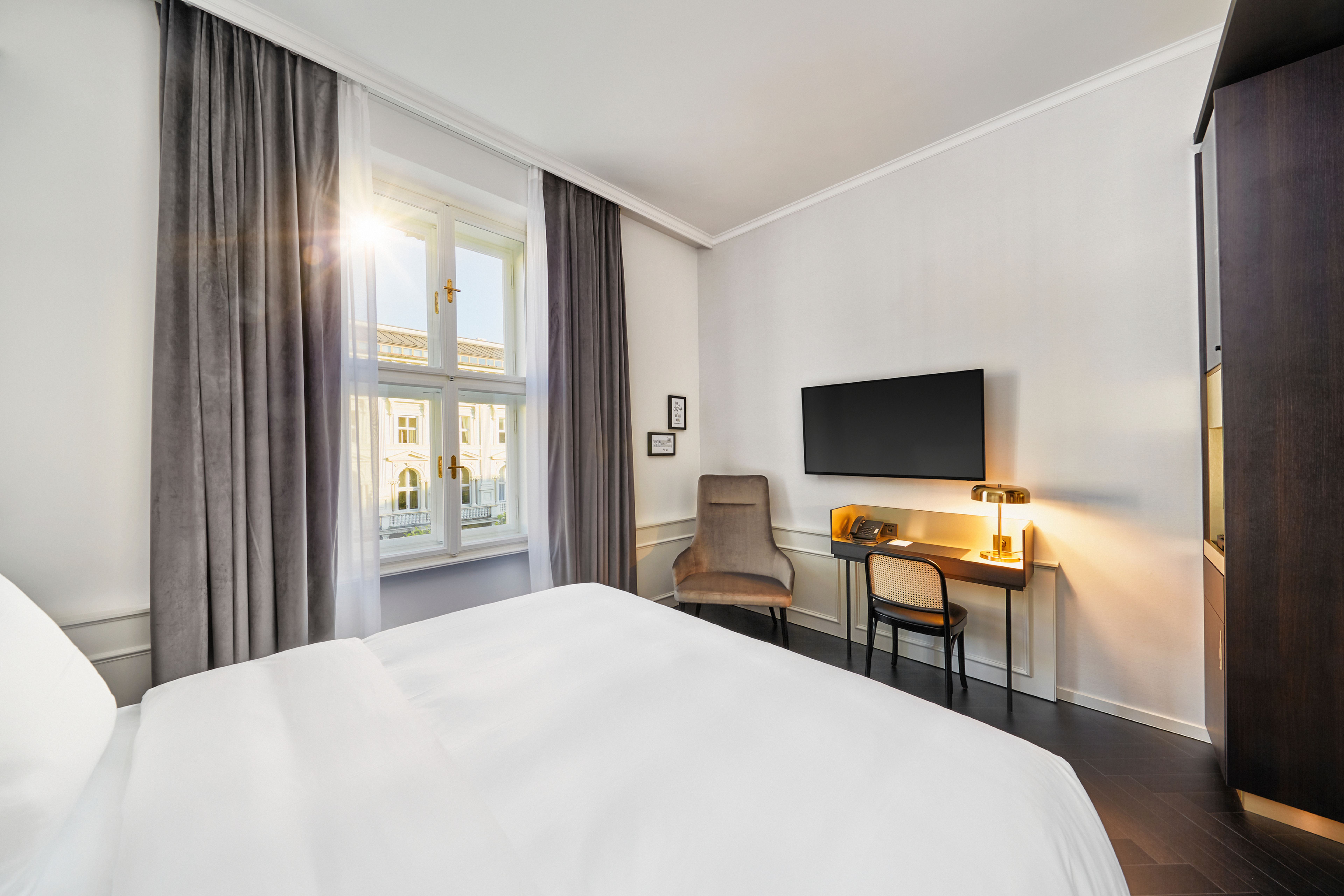 Helles, modern eingerichtetes Hotelzimmer mit großem Fenster, gemütlichem Bett, Schreibtisch, Fernseher und bequemen Stuhl. Ruhige, freundliche Atmosphäre für Erholung und Arbeit. Helles, modern eingerichtetes Hotelzimmer mit großem Fenster, gemütlichem Bett, Schreibtisch, Fernseher und bequemen Stuhl. Ruhige, freundliche Atmosphäre für Erholung und Arbeit.