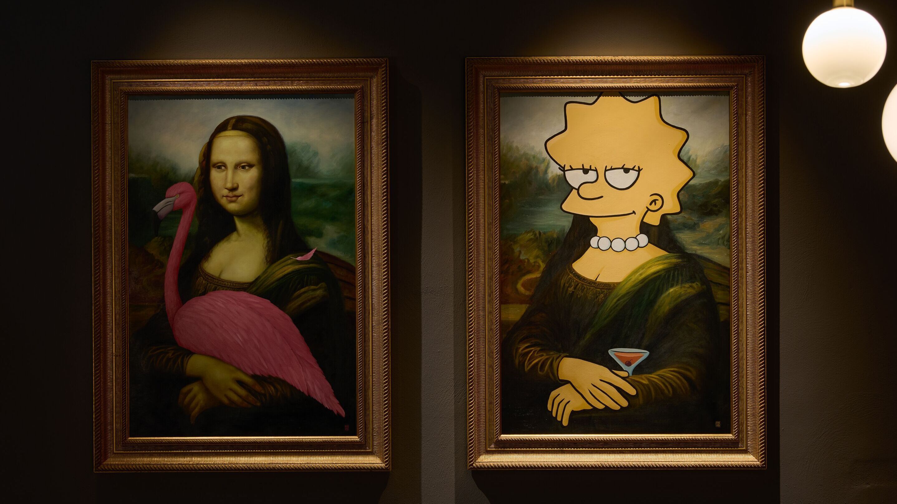 Hotel Frankfurt Metropolitan The Cloud One zwei gerahmte Gemälde an dunkler Wand: Links eine Mona Lisa mit einem pinken Flamingo, rechts eine Mona Lisa mit dem Kopf von Lisa Simpson, die einen Cocktail hält. Beide Bilder kombinieren klassische Kunst mit modernen, humorvollen Elementen.