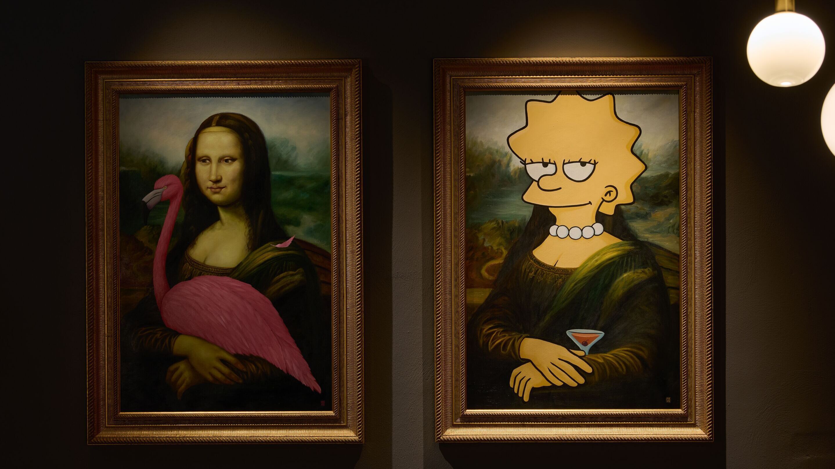 Hotel Frankfurt Metropolitan The Cloud One zwei gerahmte Gemälde an dunkler Wand: Links eine Mona Lisa mit einem pinken Flamingo, rechts eine Mona Lisa mit dem Kopf von Lisa Simpson, die einen Cocktail hält. Beide Bilder kombinieren klassische Kunst mit modernen, humorvollen Elementen.
