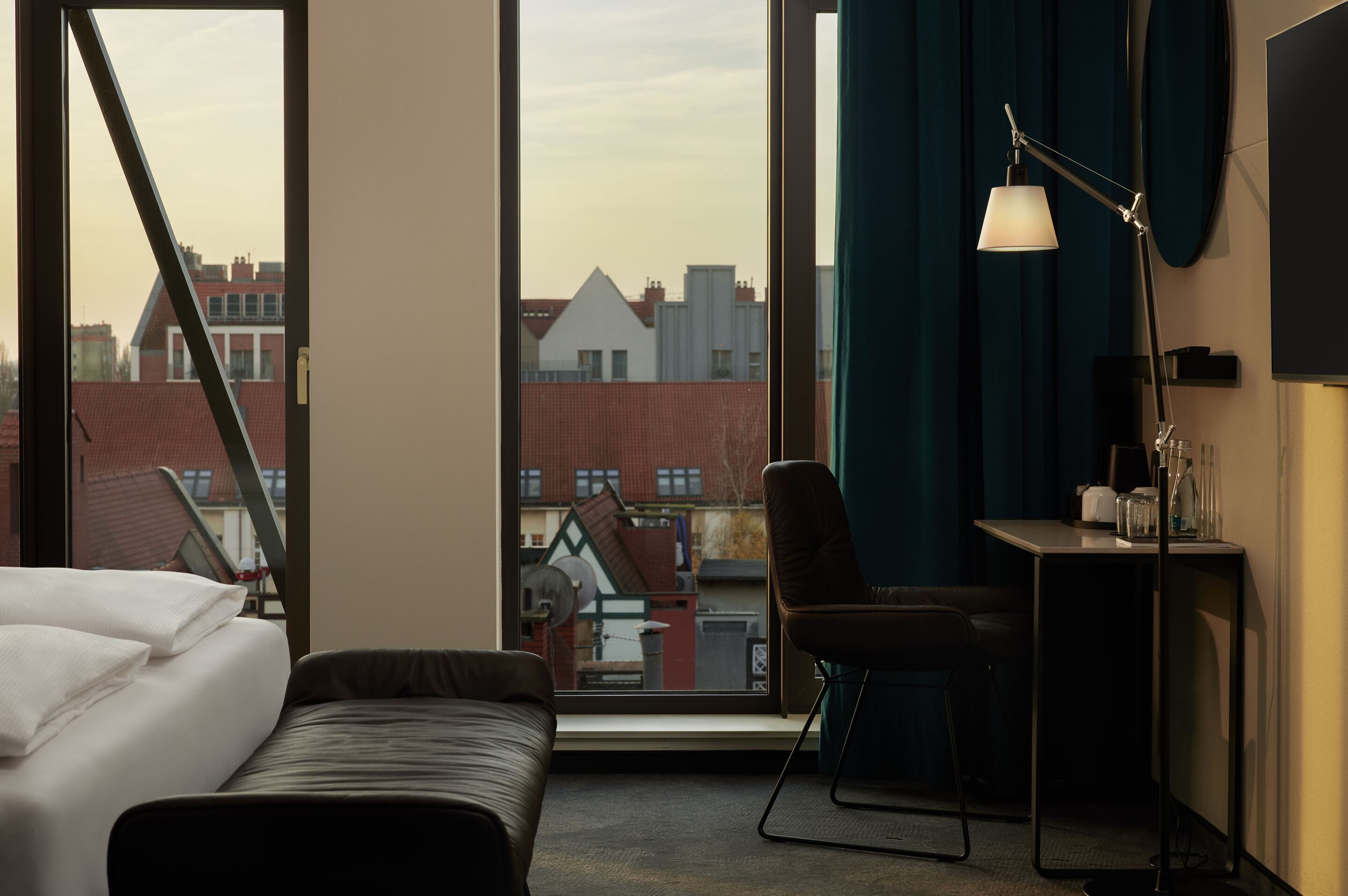 Hotel Danzig The Cloud One Zimmer mit Bettbank vor Bett, Tisch und Stuhl sowie zwei bodentiefe Fenster Hotel Danzig The Cloud One Zimmer mit Bettbank vor Bett, Tisch und Stuhl sowie zwei bodentiefe Fenster