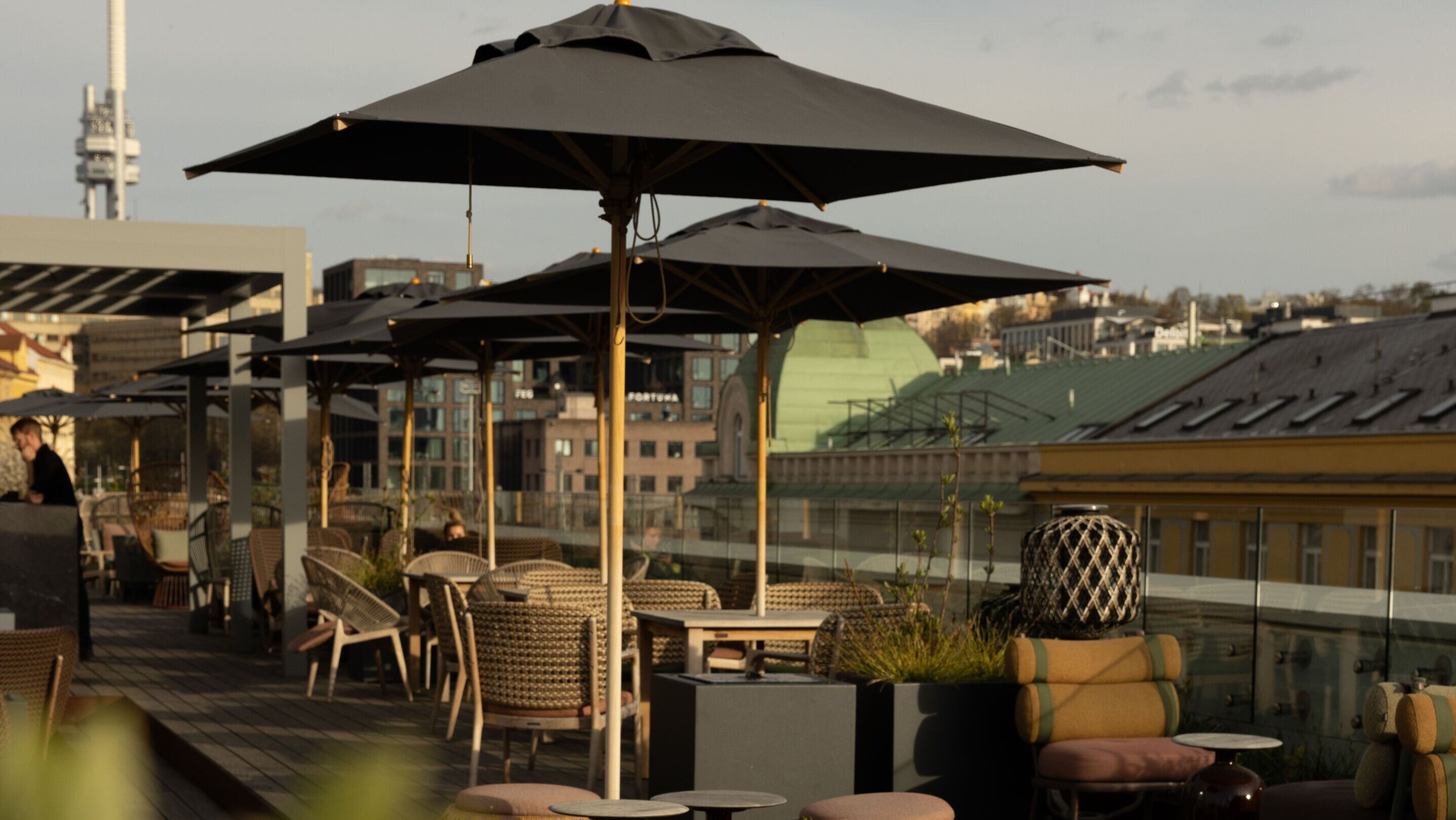 Designhotel Prag The Cloud One Dachterrasse mit mehreren Tischen und Stühlen sowie Sonnenschirme