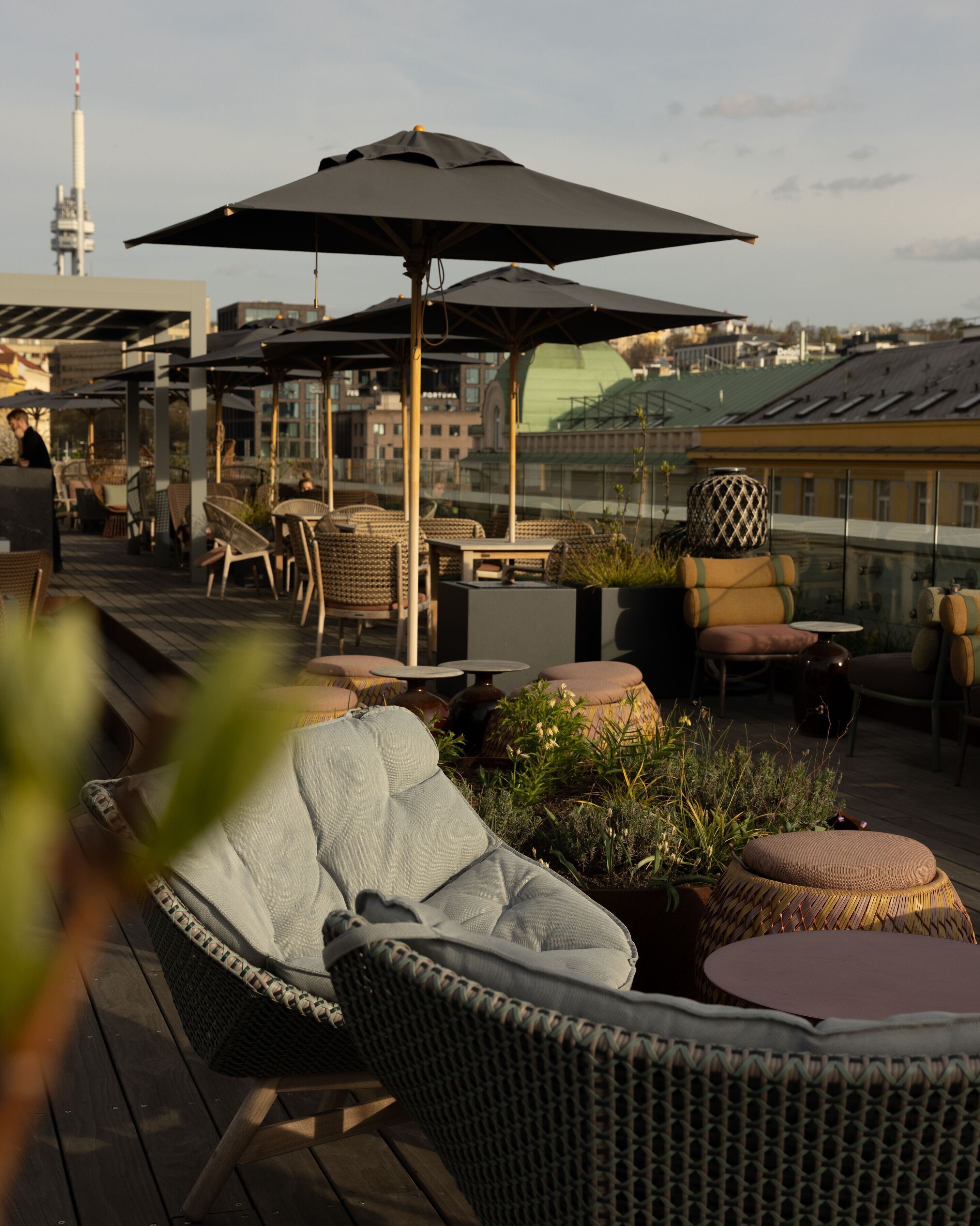 Designhotel Prag The Cloud One Dachterrasse mit mehreren Tischen und Stühlen sowie Sonnenschirme