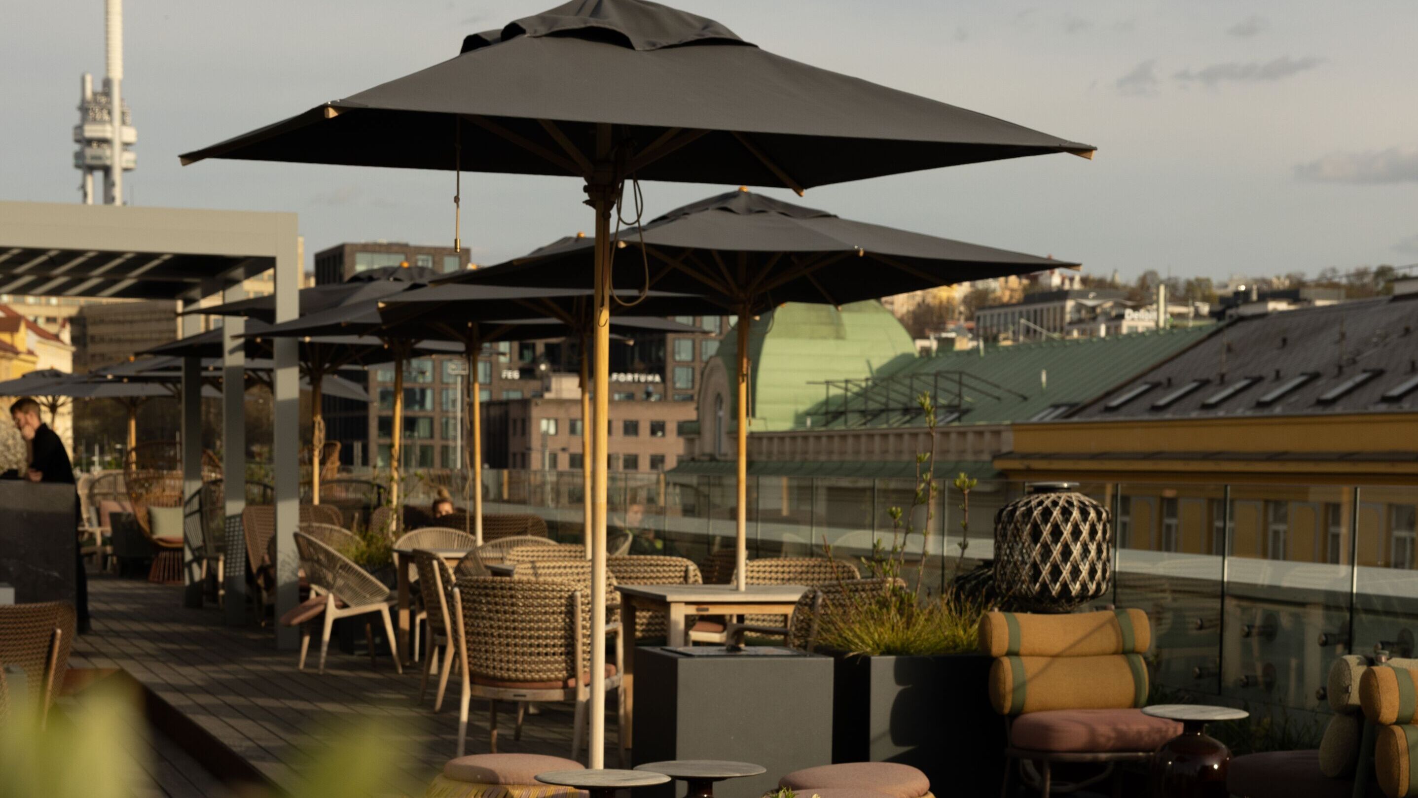 Designhotel Prag The Cloud One Dachterrasse mit mehreren Tischen und Stühlen sowie Sonnenschirme