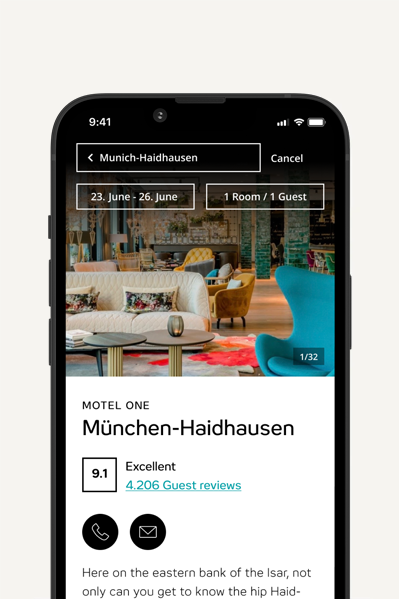 Smartphone-Display zeigt Buchungsseite für Motel One München-Haidhausen mit Daten, Gästeanzahl, Hotelbewertung 9.1 und Kontaktoptionen. Hintergrundbild zeigt gemütliche Hotel-Lounge mit Sitzmöbeln.