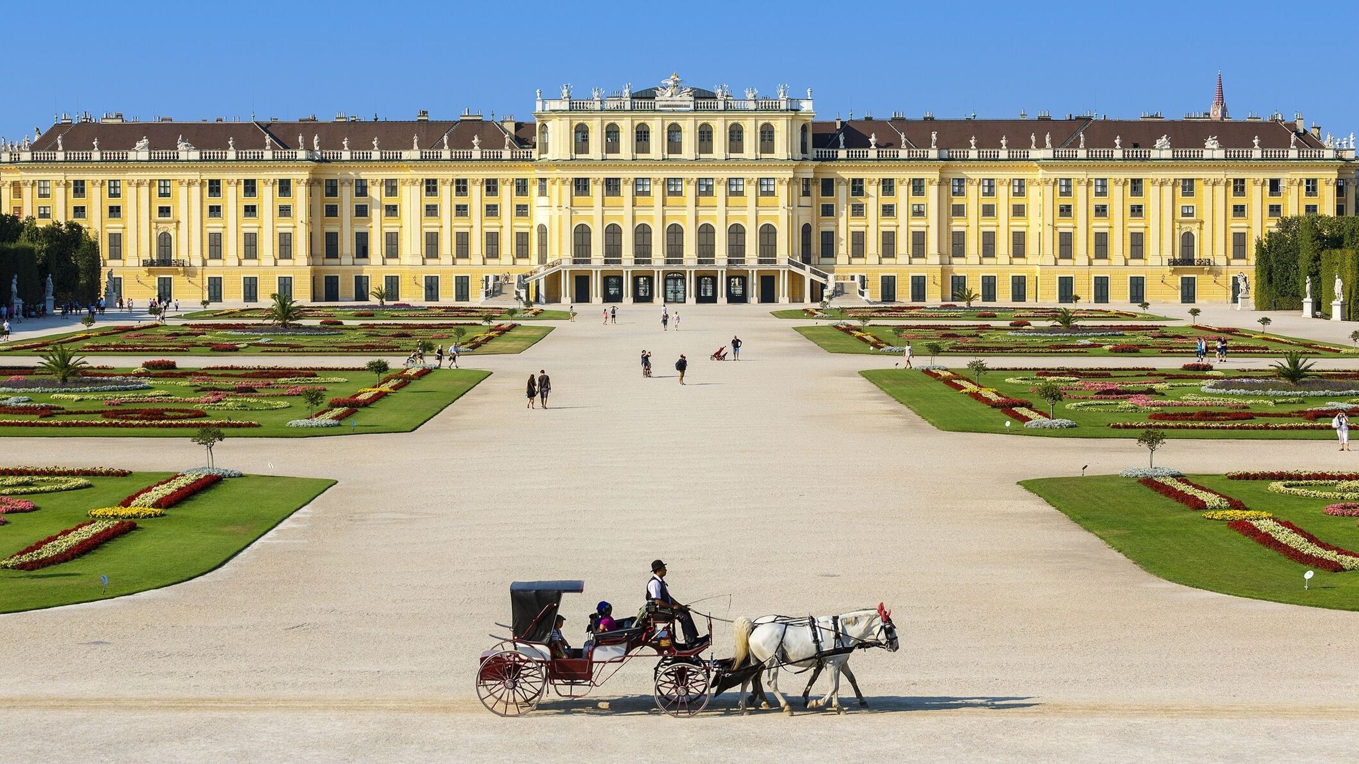 Weitläufiges Barockschloss mit symmetrischem Garten und klaren Wegen, davor eine Pferdekutsche, die eine ruhige, historische Atmosphäre vermittelt. Weitläufiges Barockschloss mit symmetrischem Garten und klaren Wegen, davor eine Pferdekutsche, die eine ruhige, historische Atmosphäre vermittelt.