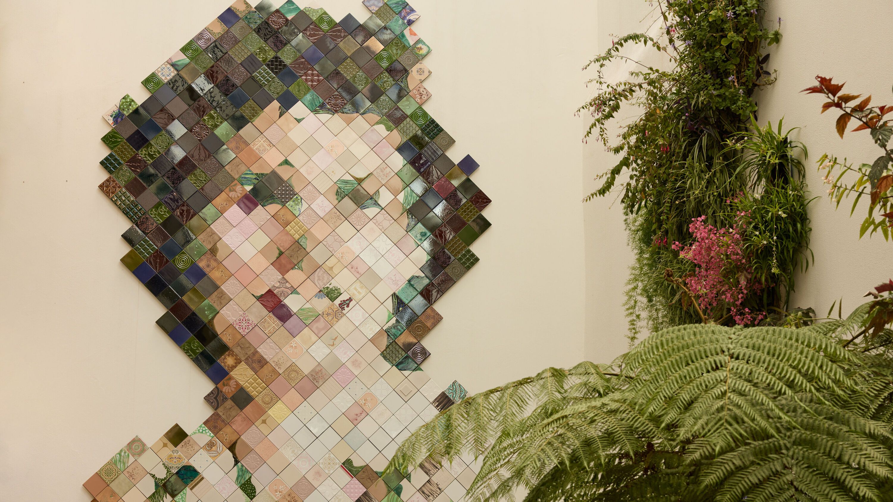 Hotel Lissabon The Cloud One Mosaikkunstwerk einer Frau mit dunklen Haaren an einer hellen Wand, umgeben von grünen Pflanzen und Farnen.
