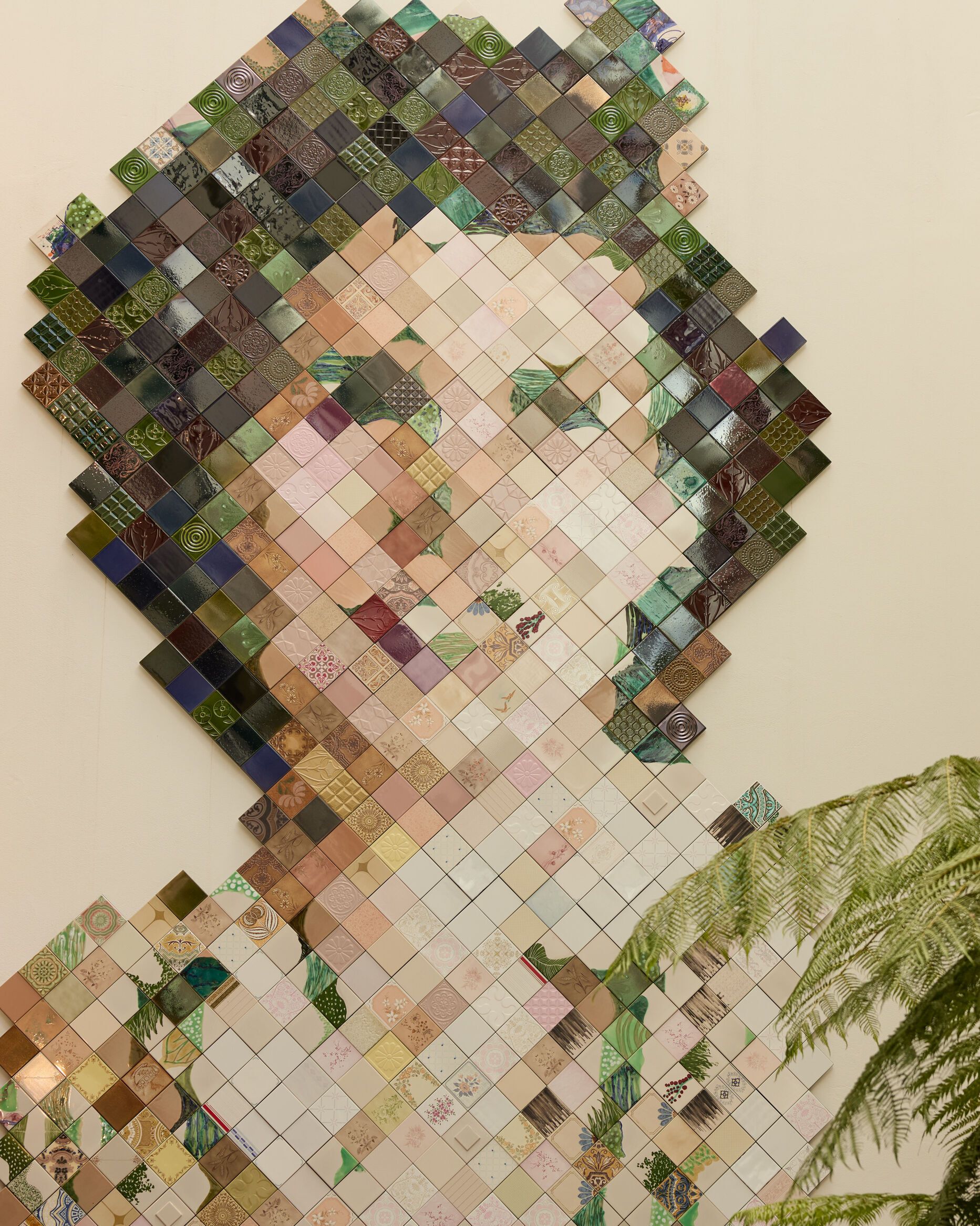 Hotel Lissabon The Cloud One Mosaikkunstwerk einer Frau mit dunklen Haaren an einer hellen Wand, umgeben von grünen Pflanzen und Farnen.