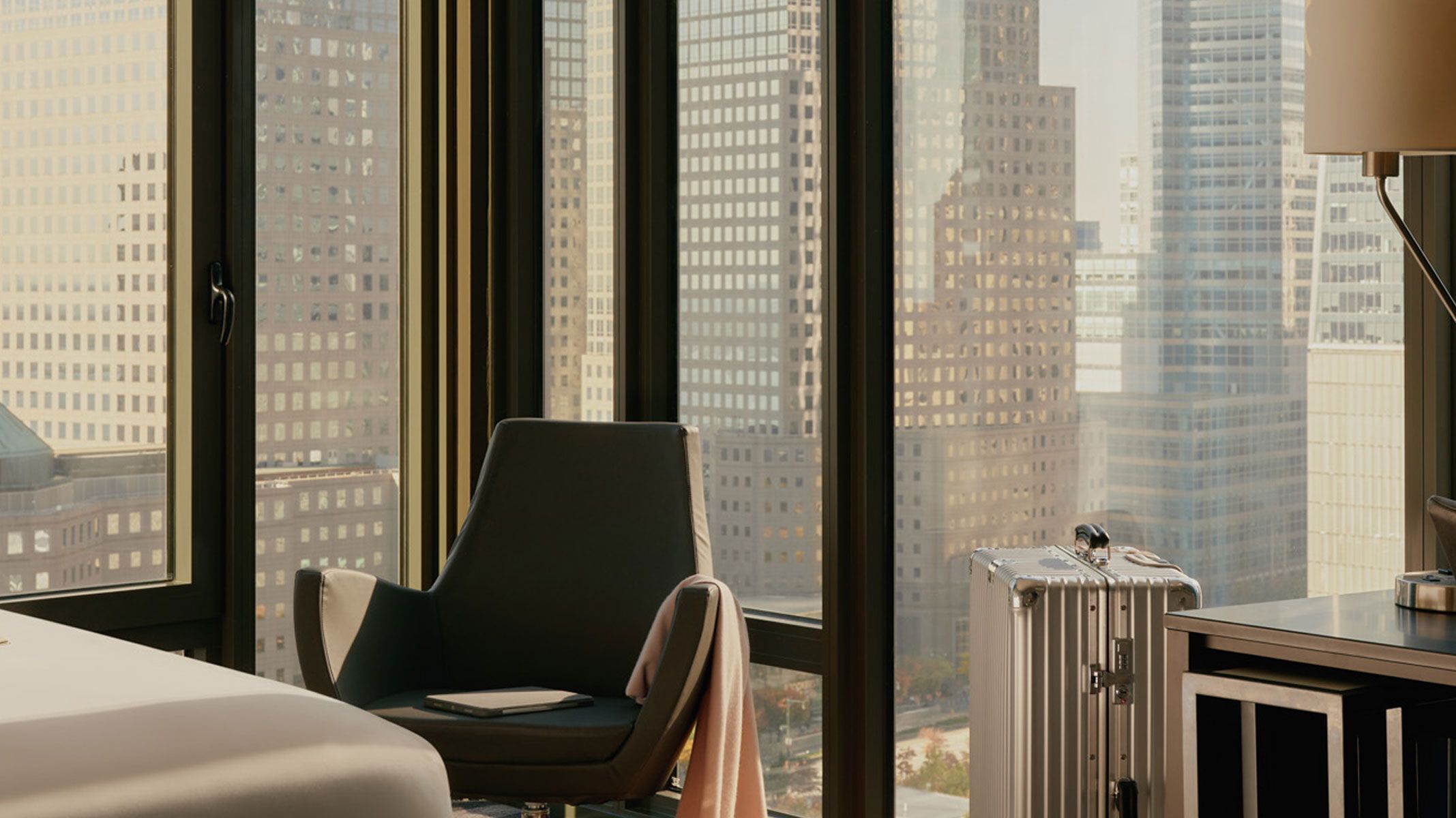 Modern eingerichteter Arbeitsplatz in Hotelzimmer mit Sitzgelegenheit, Schreibtisch und großem Fenster mit Stadtblick, ideal für Geschäftsreisende.