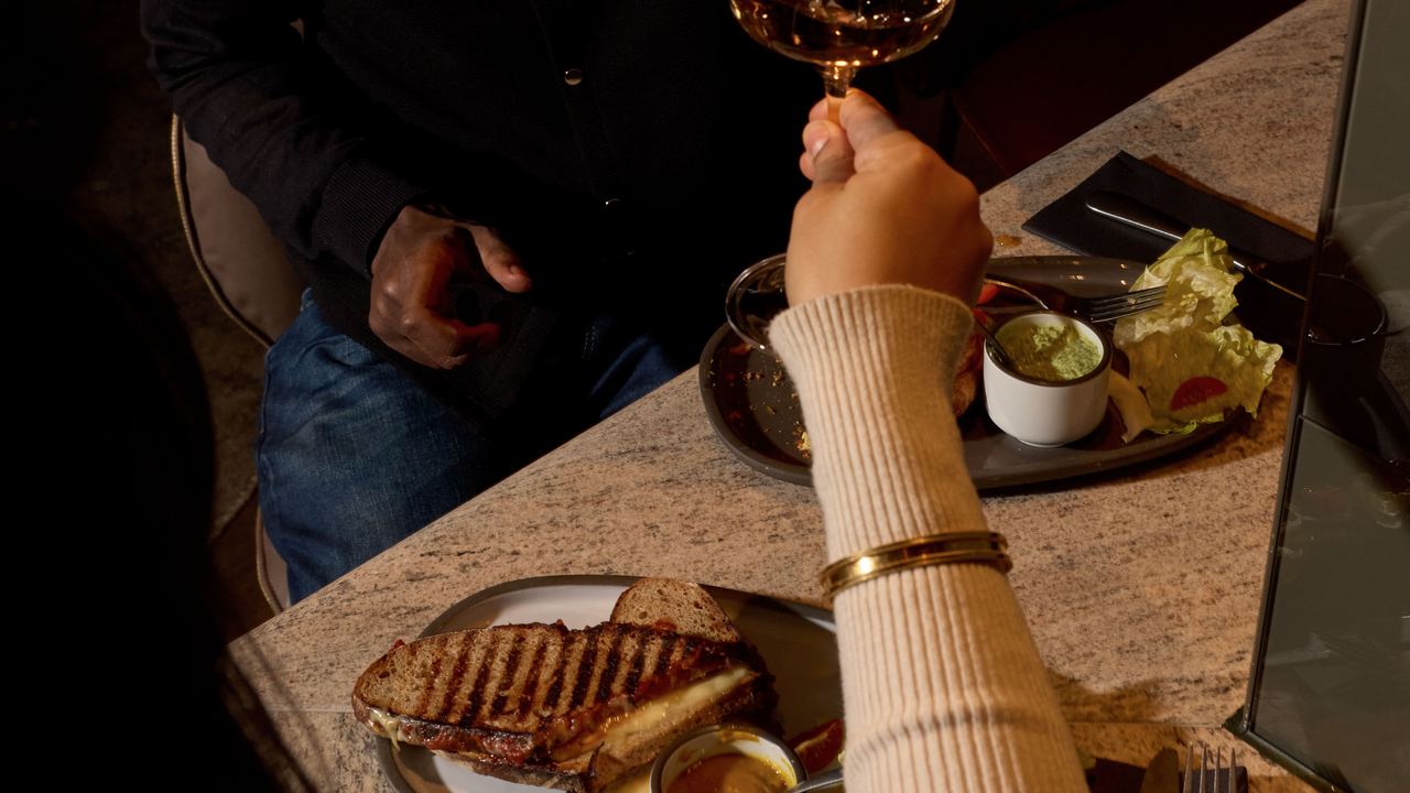 Zwei Personen stoßen in einem gemütlichen Restaurant bei gedämpftem Licht mit Weingläsern an. Auf dem Tisch liegen Teller mit Essen und Dips, Atmosphäre ist entspannt und einladend, ideal für einen genussvollen Abend zu zweit. Zwei Personen stoßen in einem gemütlichen Restaurant bei gedämpftem Licht mit Weingläsern an. Auf dem Tisch liegen Teller mit Essen und Dips, Atmosphäre ist entspannt und einladend, ideal für einen genussvollen Abend zu zweit.